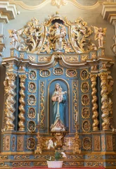  COURMAYEUR, ITALY - JULY 12, 2022:  The baroque altar with the carved polychrome satatue of Madonna in the church Chiesa di San Pantaleone  © Renáta Sedmáková