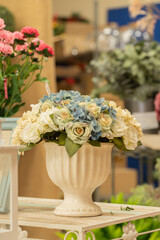 Beautiful flower arrangement in a white vase is on the table