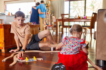 Cousins playing with wooden train set gift together at Christmas time