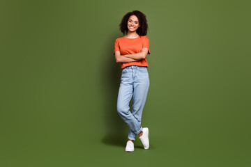 Full length photo of confident shiny woman wear orange t-shirt arms crossed empty space isolated green color background
