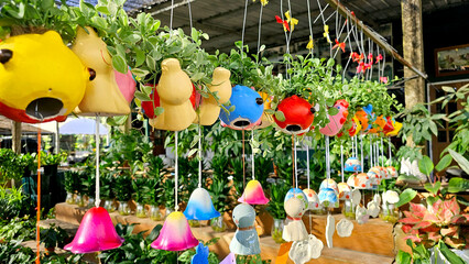 Bright and cheerful hanging garden pots shaped like animals paired with colorful wind chimes,...