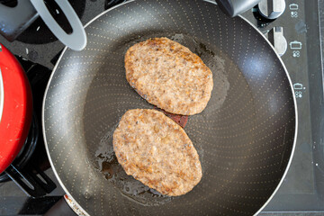 frying burger in frying pan for meal