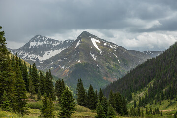 Snow capped mountains with summer storm clouds