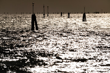 Waves backlight in Venice lagoon during the carnival 