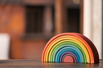 Brightly coloured wooden rainbow learning puzzle in nature-based playground environment