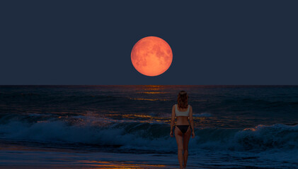 Night sky with moon in the clouds on the foreground power sea wave - Happy slim girl in red and...