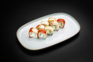 Sushi, Philadelphia rolls, unagi maki with eel. On a black background.