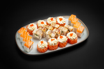 Sushi set, rolls, assorted Philadelphia, unagi with caviar, cheese, salmon. On a black background.