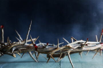 Dark moody Christian crown of thorns like Jesus Christ wore with blood drops over a rustic wood...