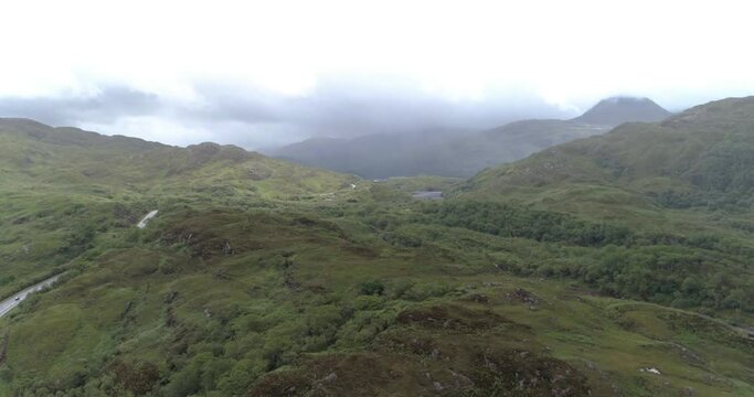 Drone view over green landscapes under a cloudy sky in Arisaig