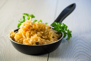 cabbage stewed with spices and carrots in a frying pan ,