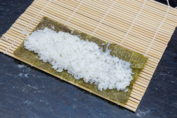 preparing sushi at home, homemade gourmet salmon roll