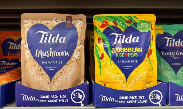 Essex, UK - January 28, 2024: Packs of Tilda gluten free favoured basmati rice on sale in a British supermarket. 