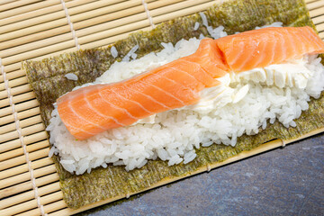 preparing sushi at home, homemade gourmet salmon roll
