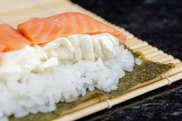 preparing sushi at home, homemade gourmet salmon roll