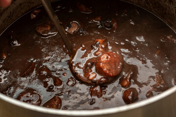 Brazilian feijoada traditional food with dark beans and pork