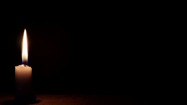 Candle flame burning on black background