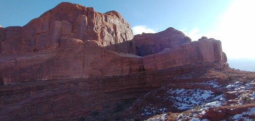 Scenic view of a massive sandstone with snow on the slope.