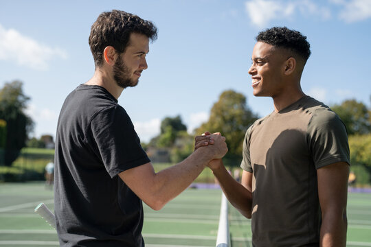 Two men shaking hands in tennis court