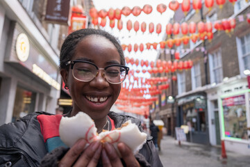 Young woman eating steamed bun in Chinatown