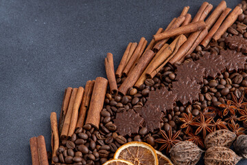 Food background. Coffee beans, cinnamon sticks, anise stars and chocolate candies top view. Copy space