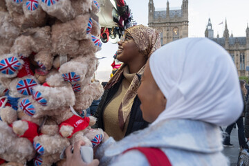 UK, London, Young female tourists in hijabs buying souvenirs