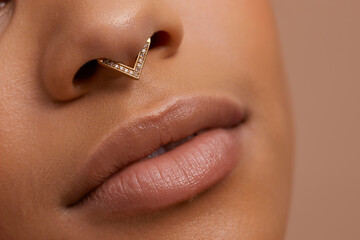 Close up portrait of non binary persons lips and pierced nose 