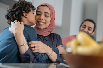 Boy (6-7) kissing mother on cheek