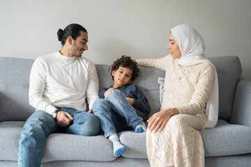 Parents and son (6-7) relaxing on sofa at home