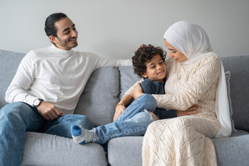 Fototapeta premium Parents and son (6-7) relaxing on sofa at home