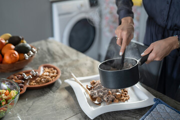 Close-up of woman putting food on plate