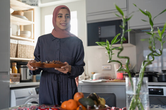 Smiling Woman In Hijab Putting Food On Table