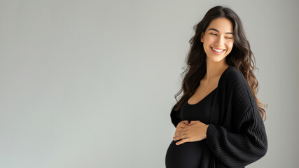 Hispanic pregnant woman with pregnancy belly, in soft black clothes