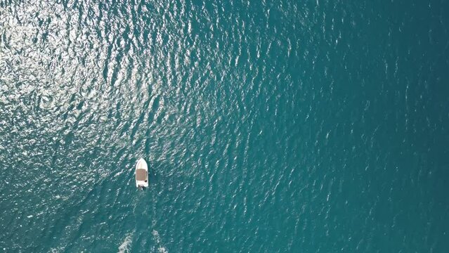 Aerial view of a white boat in a tranquil azure sea