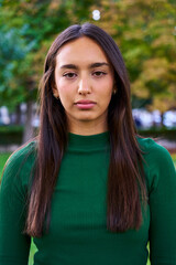 Vertical portrait of a young brunette woman looking at camera with a serious face gesturing...