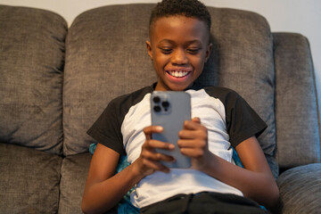 Boy with smart phone sitting on sofa