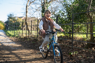Fototapeta premium Boy (6-7) riding bike in countryside