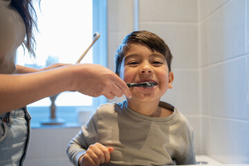 Mother and son (6-7) brushing teeth together