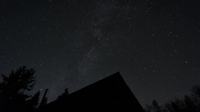 Midnight sky with astronomical object above silhouette of house and trees.