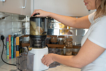 Woman using blender in kitchen