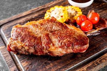 Grilled Ribeye Steak on wooden board, prime cowboy steak on dark background