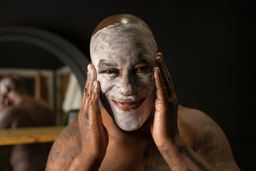 Man applying face mask in bathroom