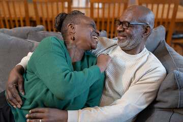 Smiling senior couple hugging on sofa
