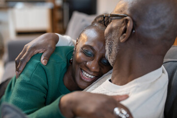 Smiling senior couple hugging on sofa