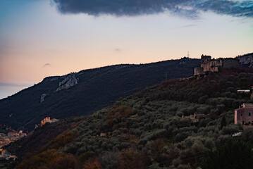 Obraz premium sunset over the castle in the middle of mountains , Italy