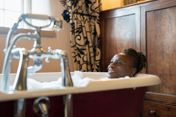 Smiling senior woman taking bubble bath