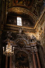 Naklejka premium A vertical side camera shot inside the beautiful Church - San Pietro (Borgio, Borgio Verezzi), Italy, Liguria, beautiful sun rays inside the church