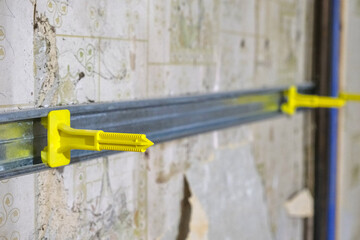 Intermediate support for fuuring channels, used for metal-framed wall insulation from the inside.