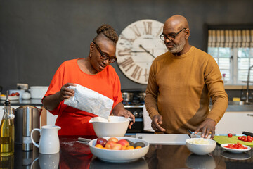 Senior couple preparing meal in kitchen
