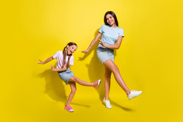 Fototapeta na wymiar Photo of two energetic girls kids have weekend party dance together isolated over shine color background